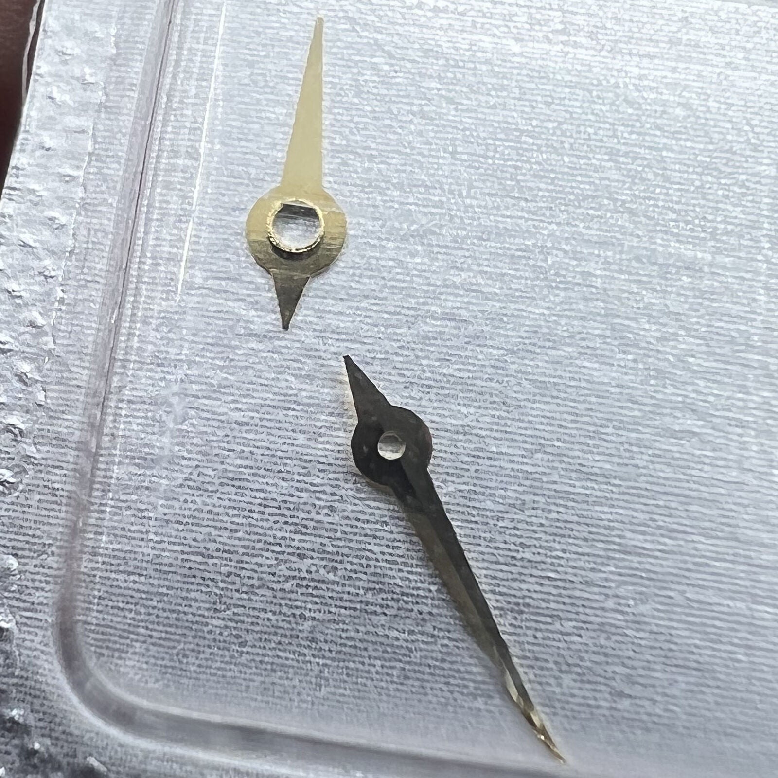 Golden watch hands set with hour, minute, and second hands for 976.001 movement.