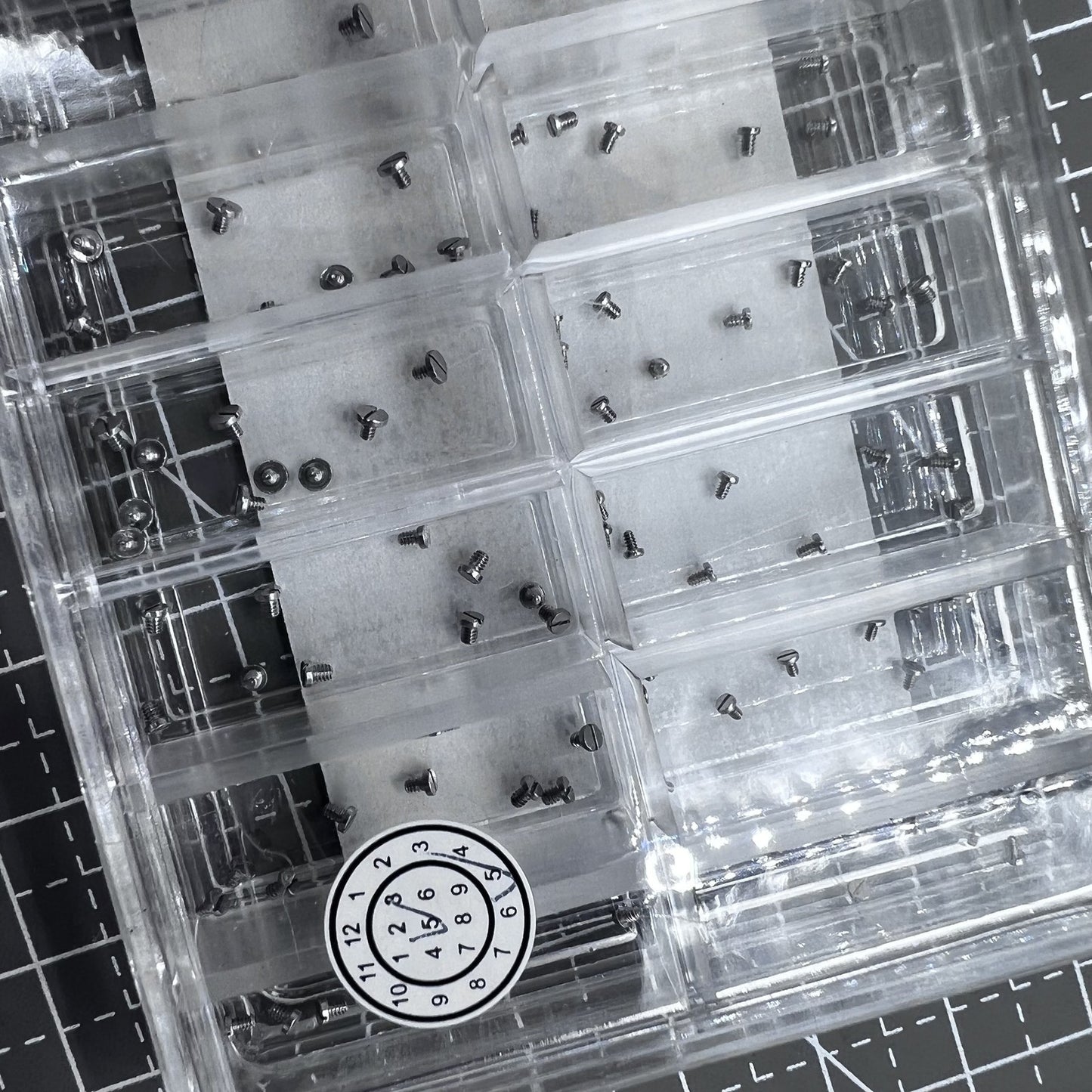 Set of 180 stainless steel mini screws for watch case backs, straight line head design.