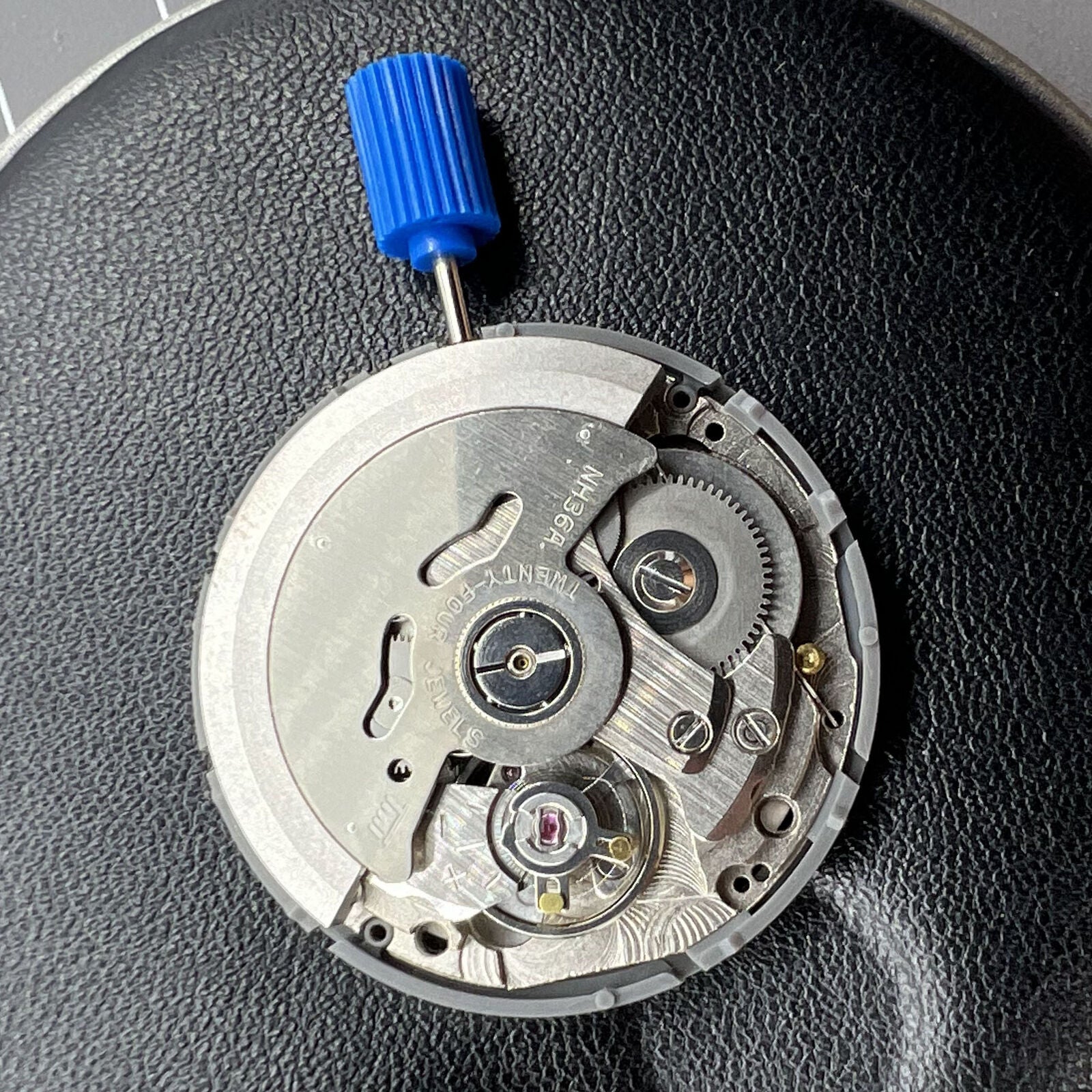Miyota NH36A black-finished watch movement with green lume and 3-position crown for accurate time adjustment.