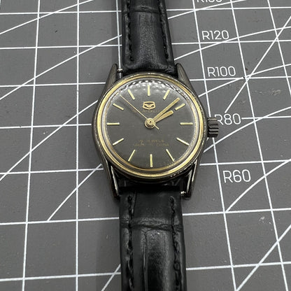 Seagull ladies watch with black case, golden nail markers, manual mechanical movement, and shock resistance.