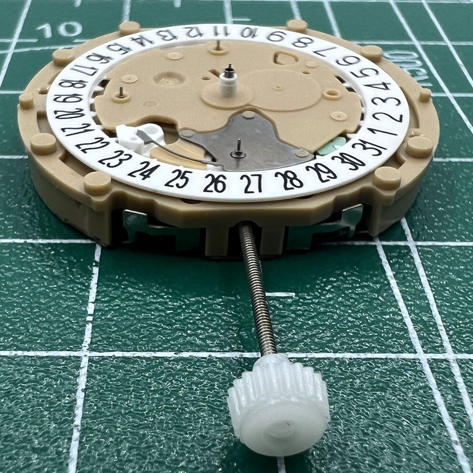 Sunon PE60 quartz watch movement with date window at 6 o'clock, 3-hand precise timekeeping mechanism.