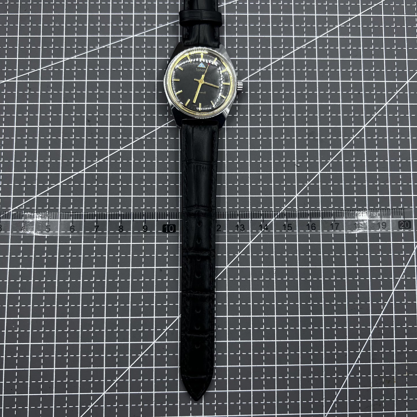 Taihang 32mm manual watch with black strap, gold markers, and black dial for classic elegance.
