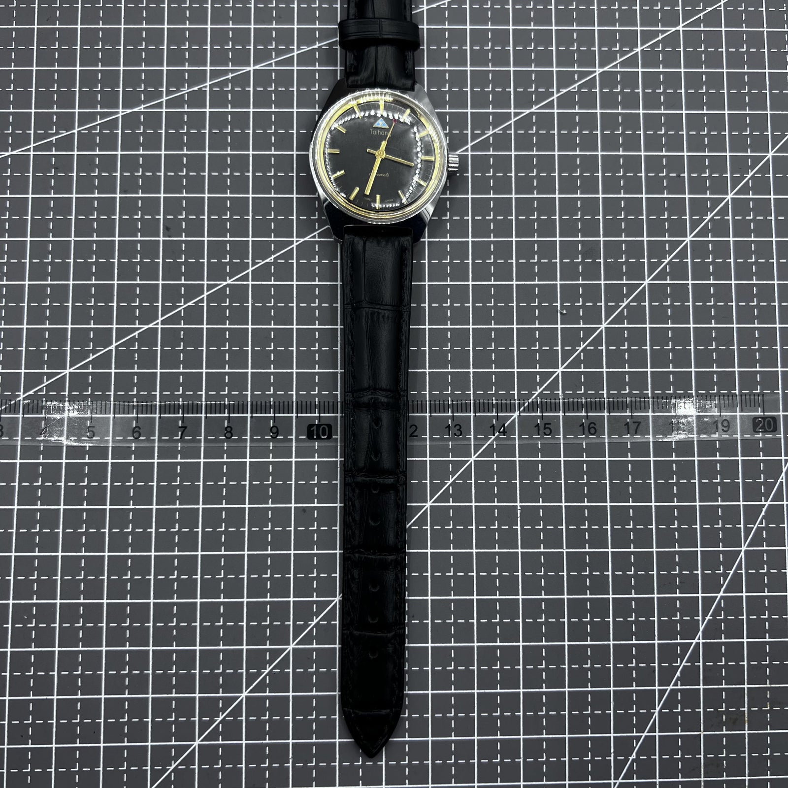Taihang 32mm manual watch with black strap, gold markers, and black dial for classic elegance.