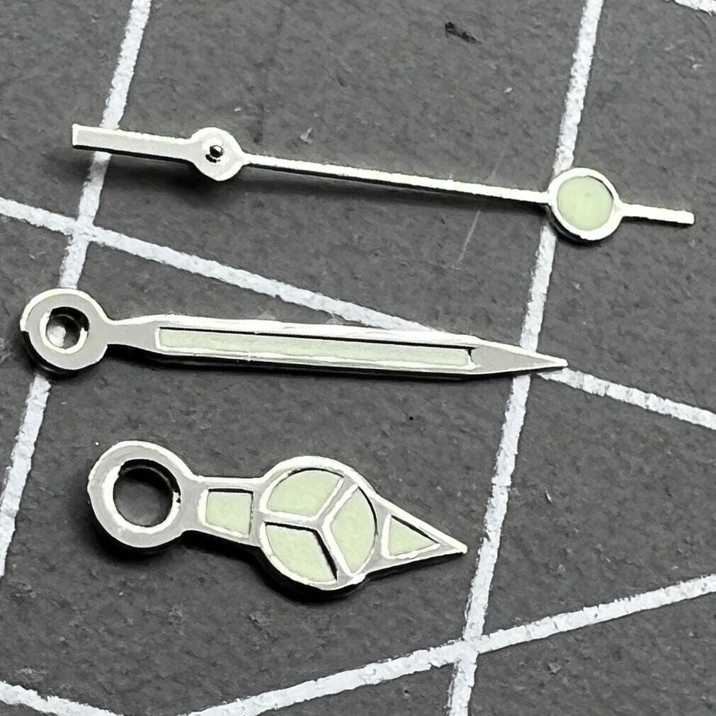 Silver-trimmed green lume watch hands set by Miyota for 2035 movement, boosting readability and style.