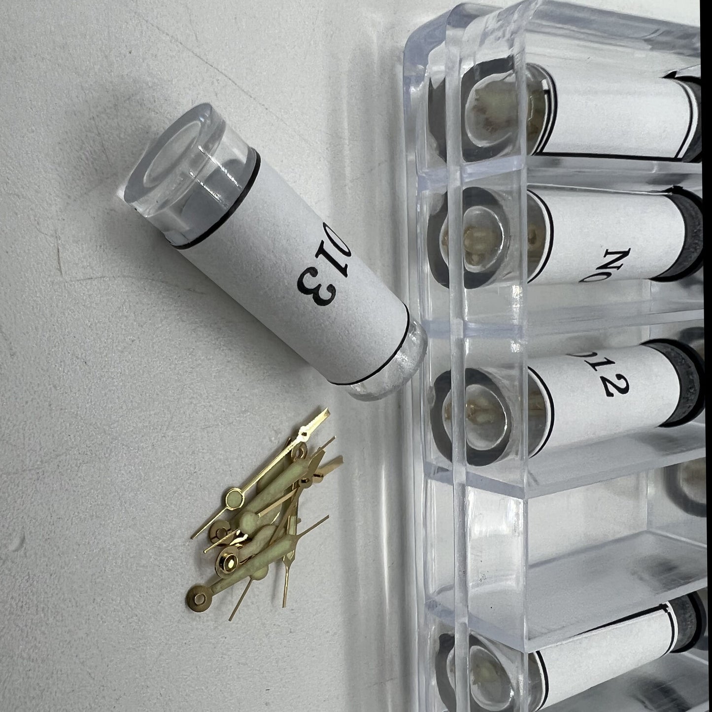 Golden luminous hour and minute hands set by Watch Parts, 51-piece assortment for accurate watch repairs.