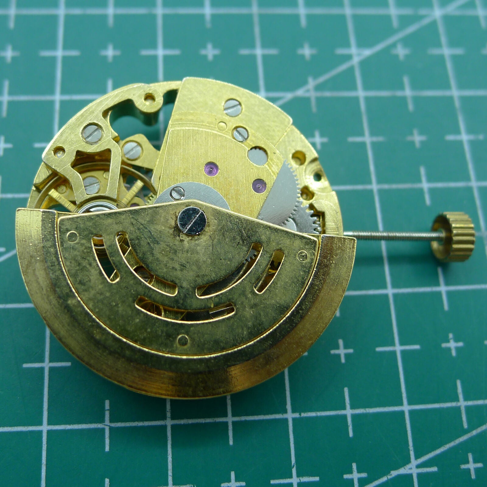 Golden 26.5mm DANDONG 7120 automatic watch movement with hollow design and precise mechanical craftsmanship.