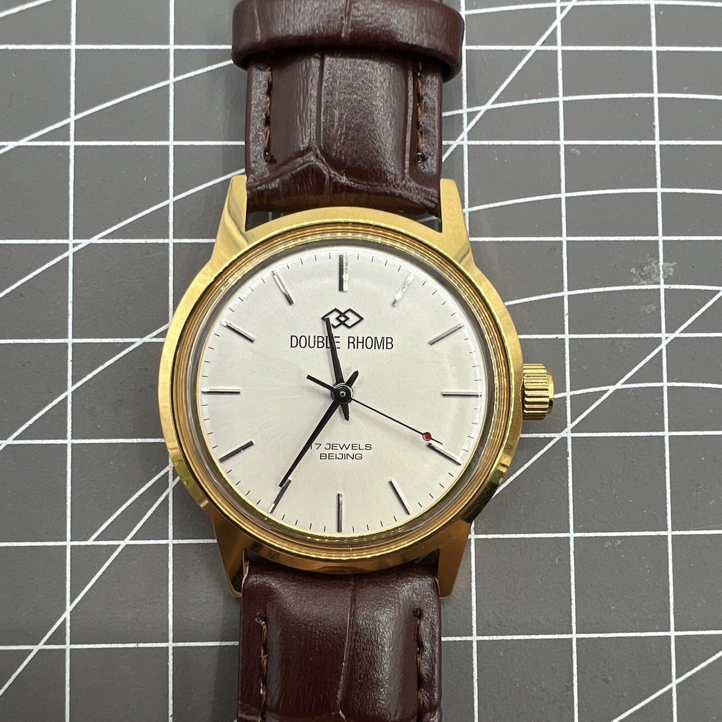 Beijing Double Rhomb mechanical watch with gold case and silver nail markers, elegant style for formal occasions.