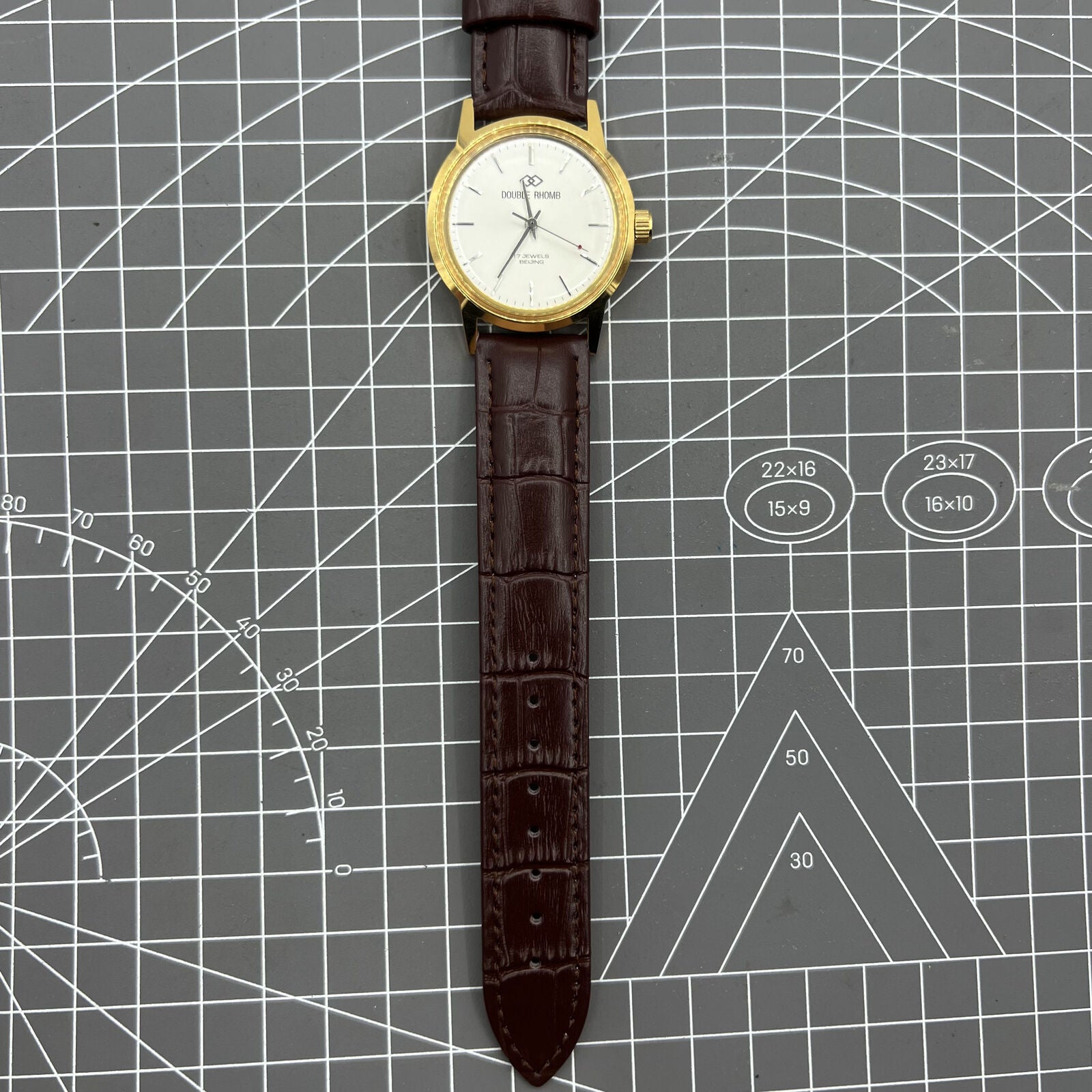 Beijing Double Rhomb mechanical watch with golden case, silver nail markers, and elegant classic design.