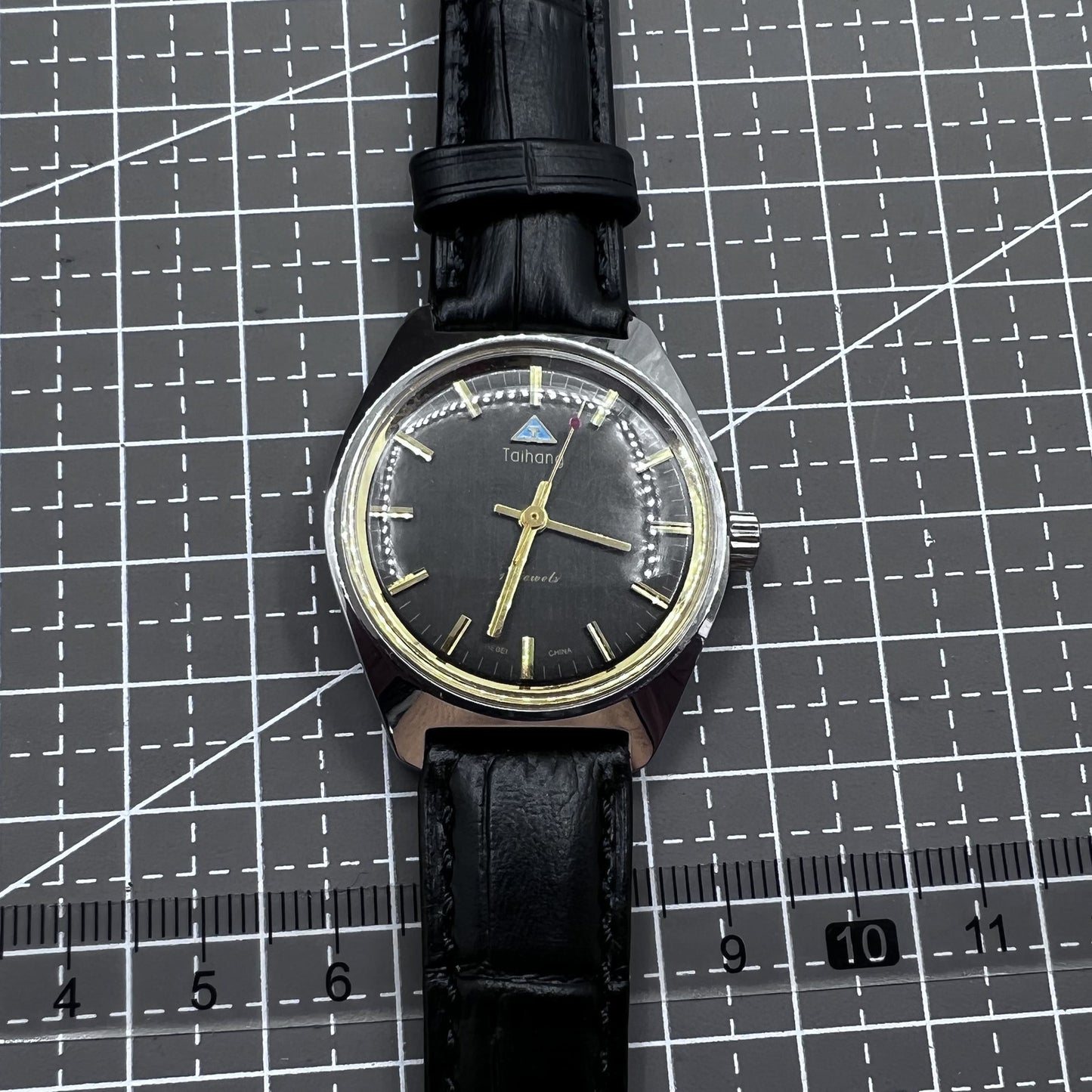 Taihang 32mm manual mechanical watch with black strap, gold markers, and black dial for classic elegance.