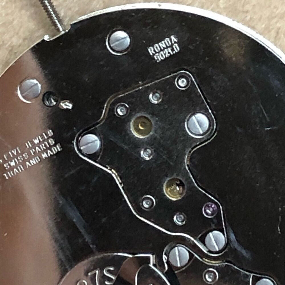 Swiss Part Ronda 5021.D watch movement with 5 hands and black date wheel at 6 o'clock, precise timekeeping mechanism.