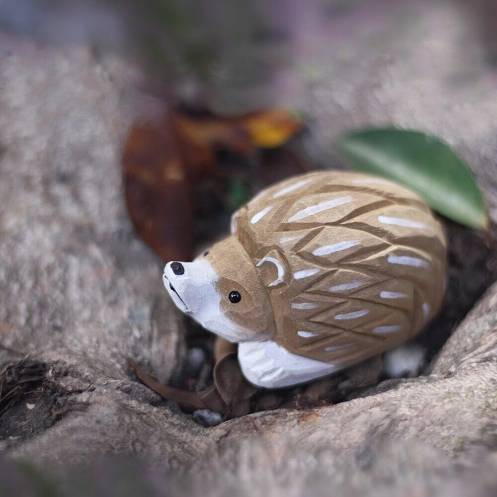 Handmade lying little hedgehog wooden figurine, perfect decorative artwork for home or office decor.
