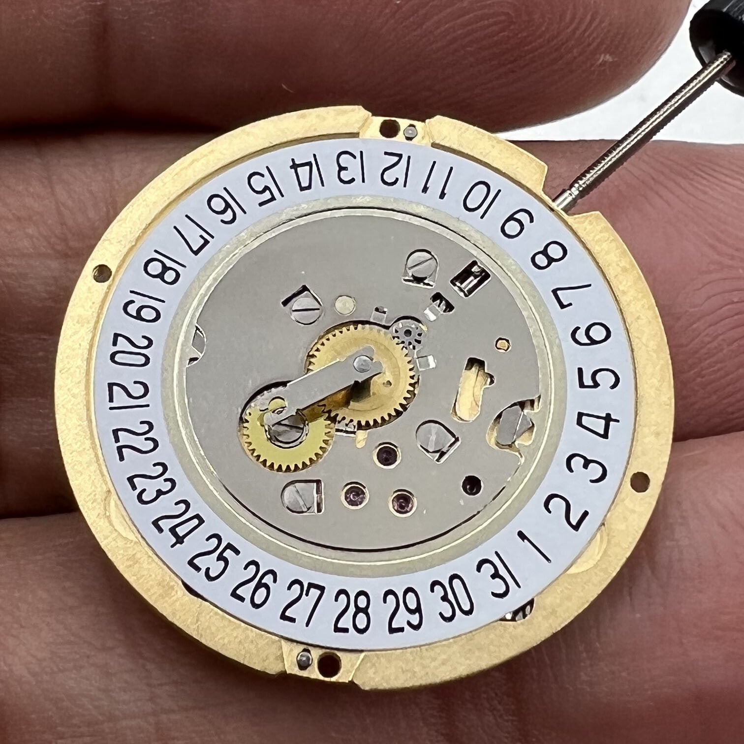 Swiss Made Ronda 1006 Slimtech golden quartz watch movement with date display at 6 o'clock, precision timekeeping part.