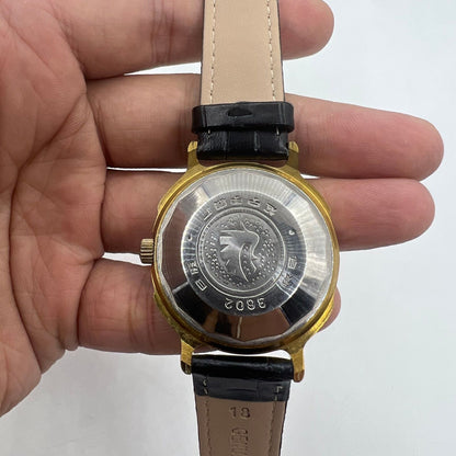 37mm automatic watch with black dial, gold Roman numerals, and 33-jewel movement.