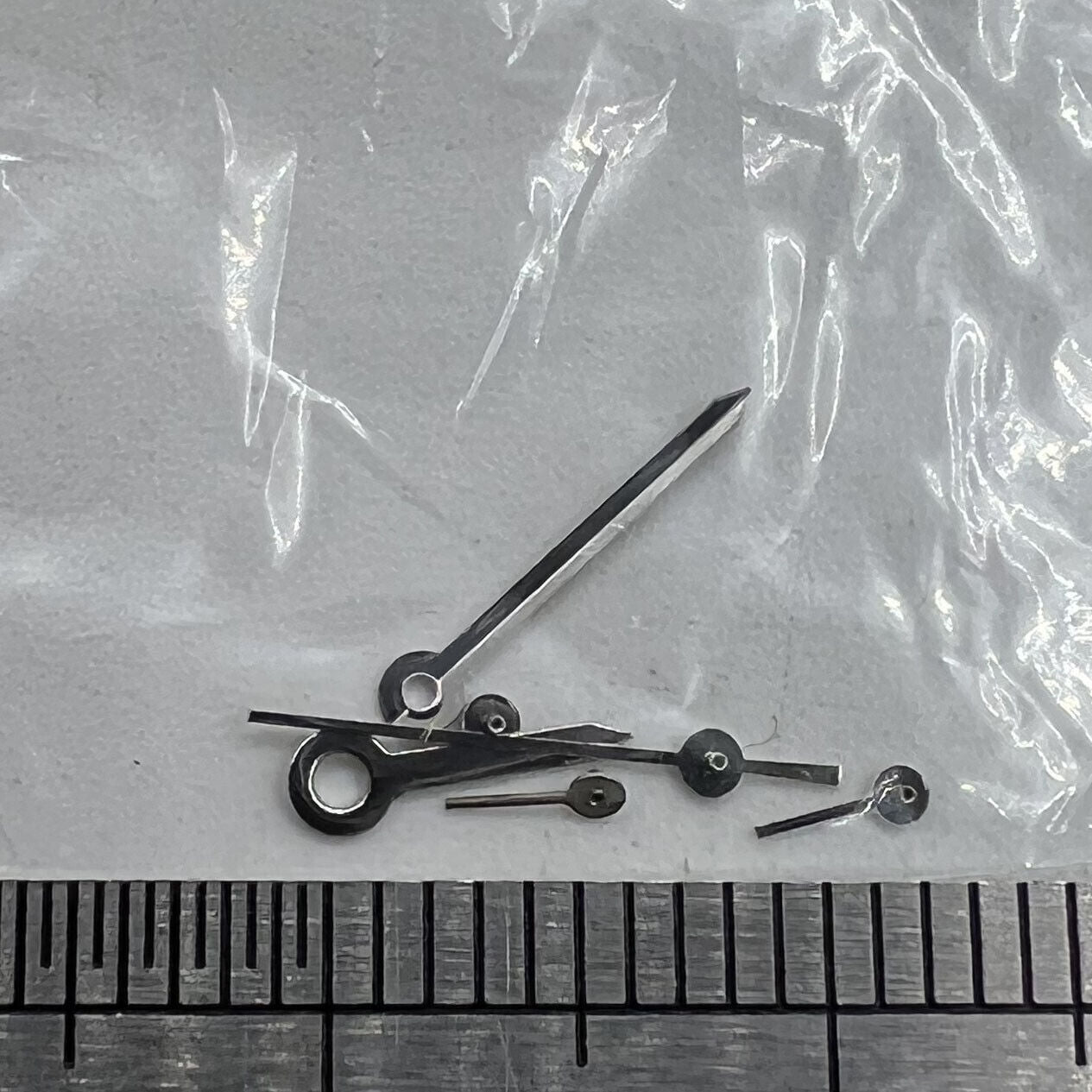 Silver-trimmed 9.5mm arrow-shaped watch hand for Epson VX series, precise fit for VX3J, VX9J, VX7J models.