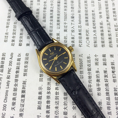 Black round case ladies watch by Tianjin Seagull with gold nail markers and manual mechanical movement.