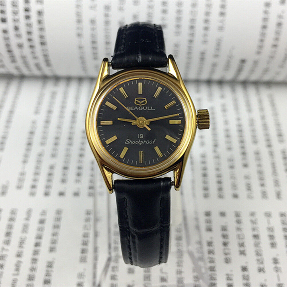 Tianjin Seagull ladies watch with black round case, golden nail markers, and manual mechanical movement for elegant style.