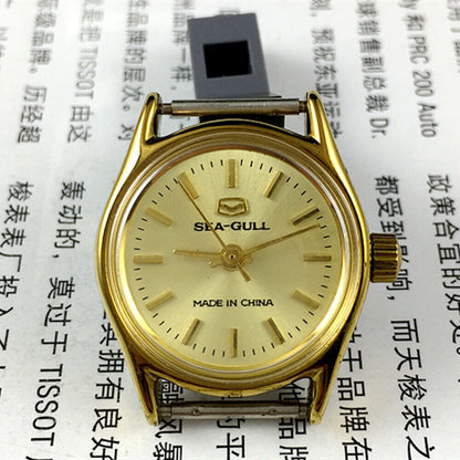 Elegant 26mm Seagull ladies watch with golden round case and manual mechanical movement, featuring a stylish band.