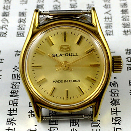 27mm round gold-tone Tianjin Seagull ladies watch with manual mechanical movement and elegant nail hour markers.