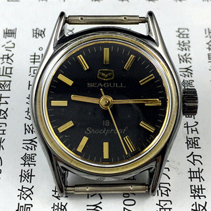 Seagull black case ladies watch with golden hands, shock-resistant manual mechanical movement for elegant timekeeping.