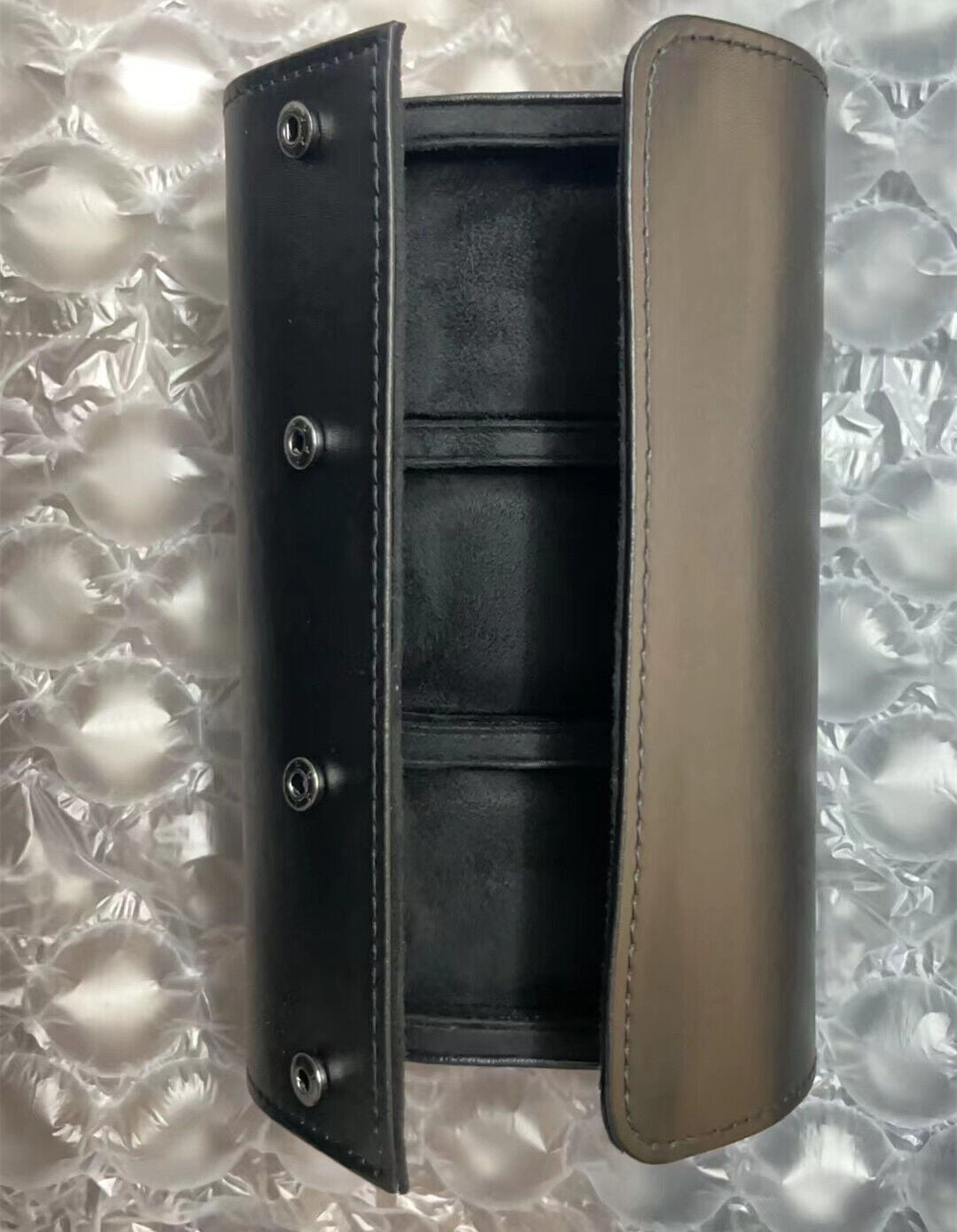 Black leather travel watch case, 3-slot portable organizer for secure watch storage on the go.