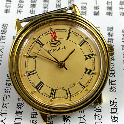 Tianjin Seagull 35mm watch with golden case, manual mechanical movement, elegant round dial design.