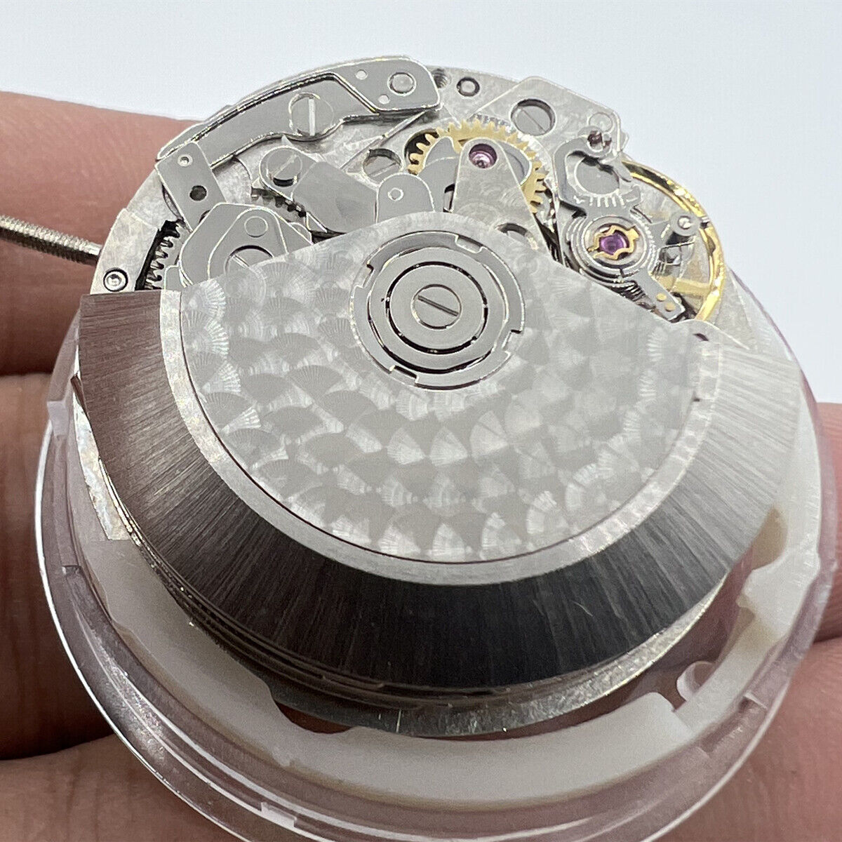 Close-up of Asian 7750 automatic chronograph movement by ETA, highlighting 3, 6, and 9 o'clock mechanism details.