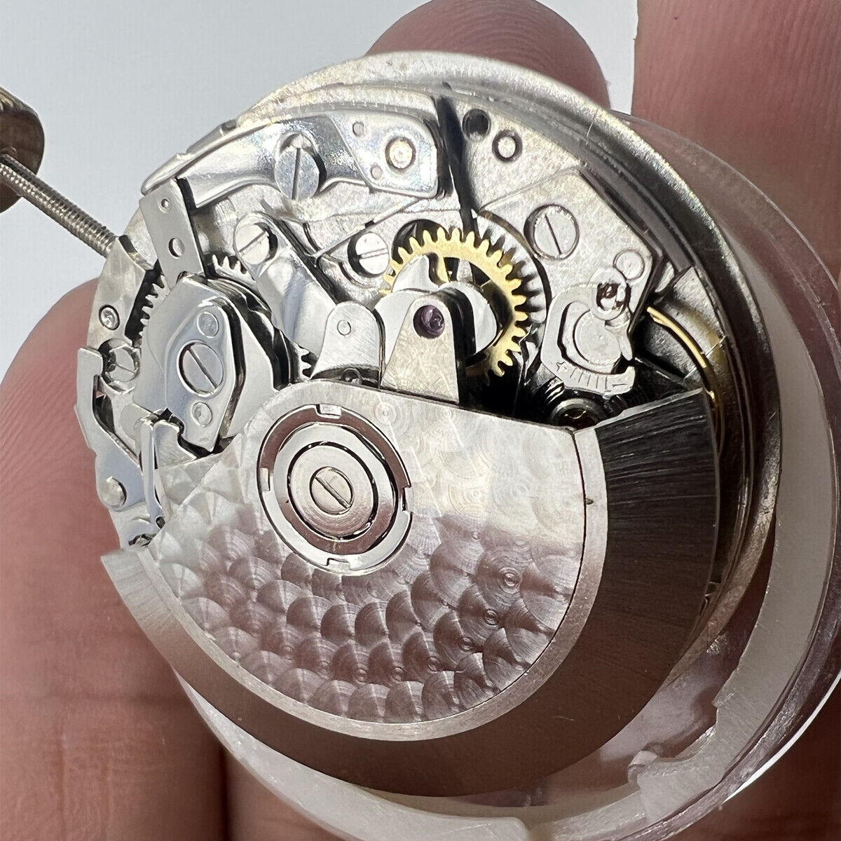 Asian 7750 automatic chronograph movement by ETA showing detailed gears at 3, 6, and 9 o'clock positions.