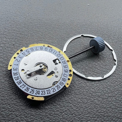 Swiss Ronda 775 quartz watch movement with golden finish, date at 6, and three hands.