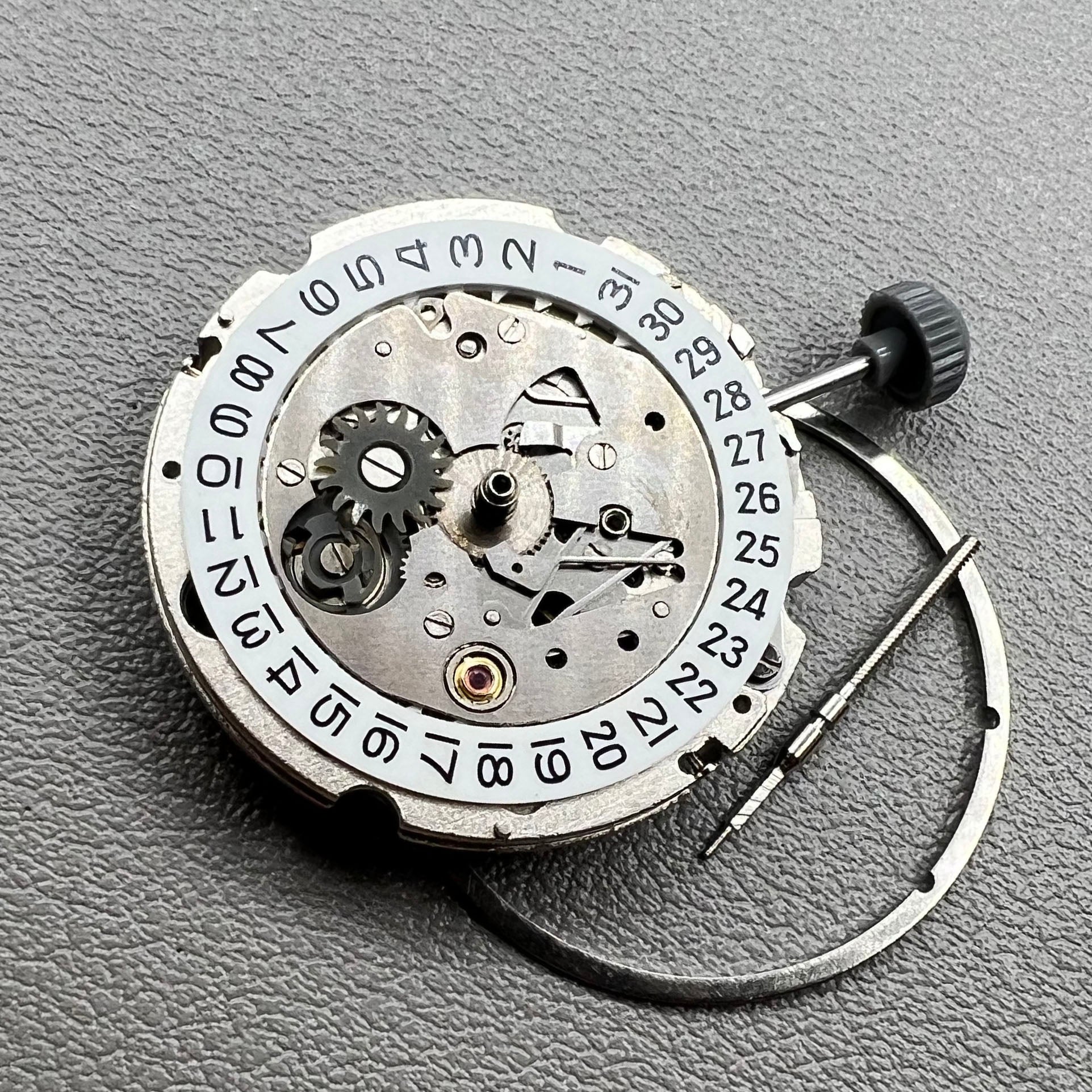 Close-up of Japan Miyota 8200 movement with single date display at 3 o'clock on watch accessory.