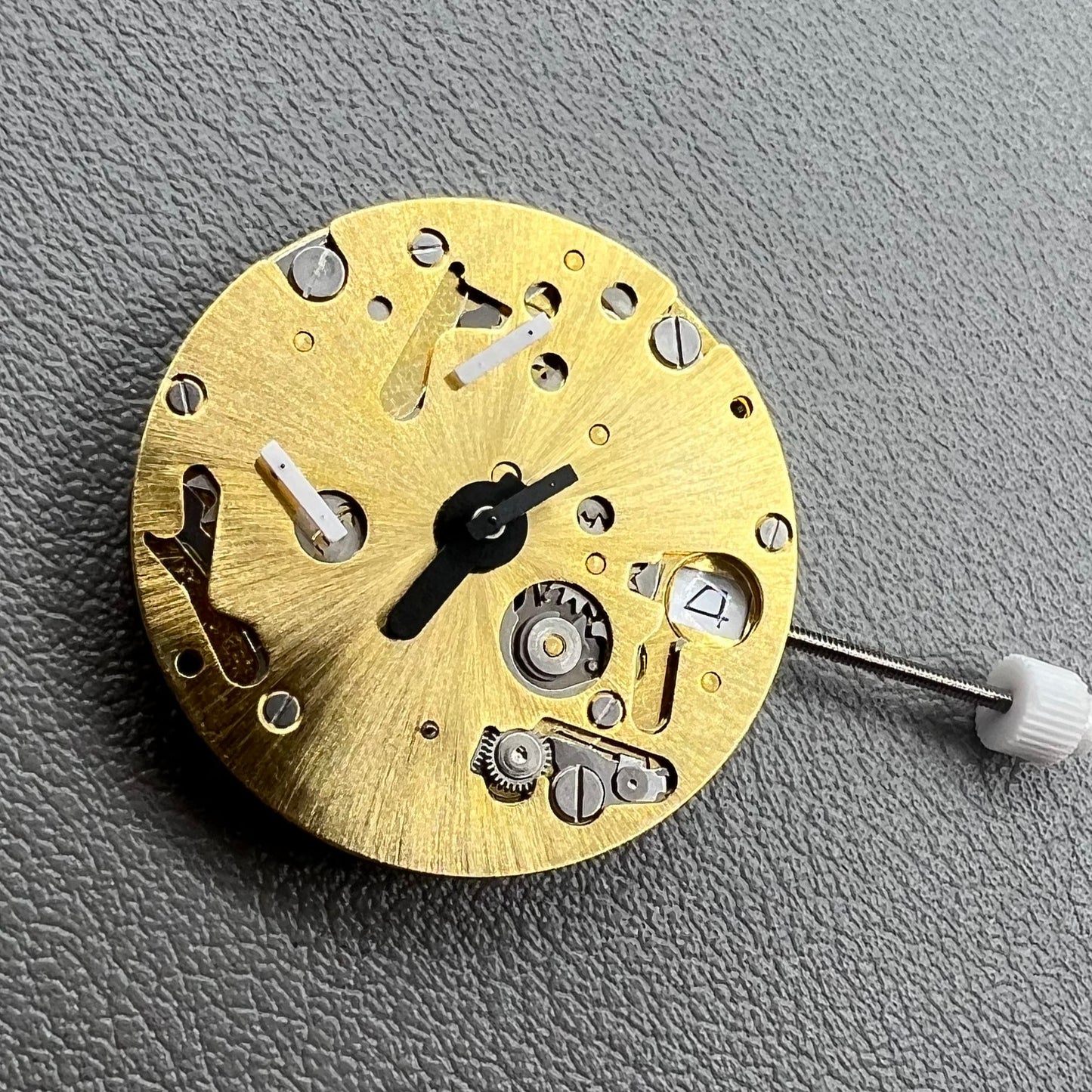 Swiss ISA 9232 quartz watch movement with six hands, date at 3, small seconds at 6/9/12, precision timekeeping.