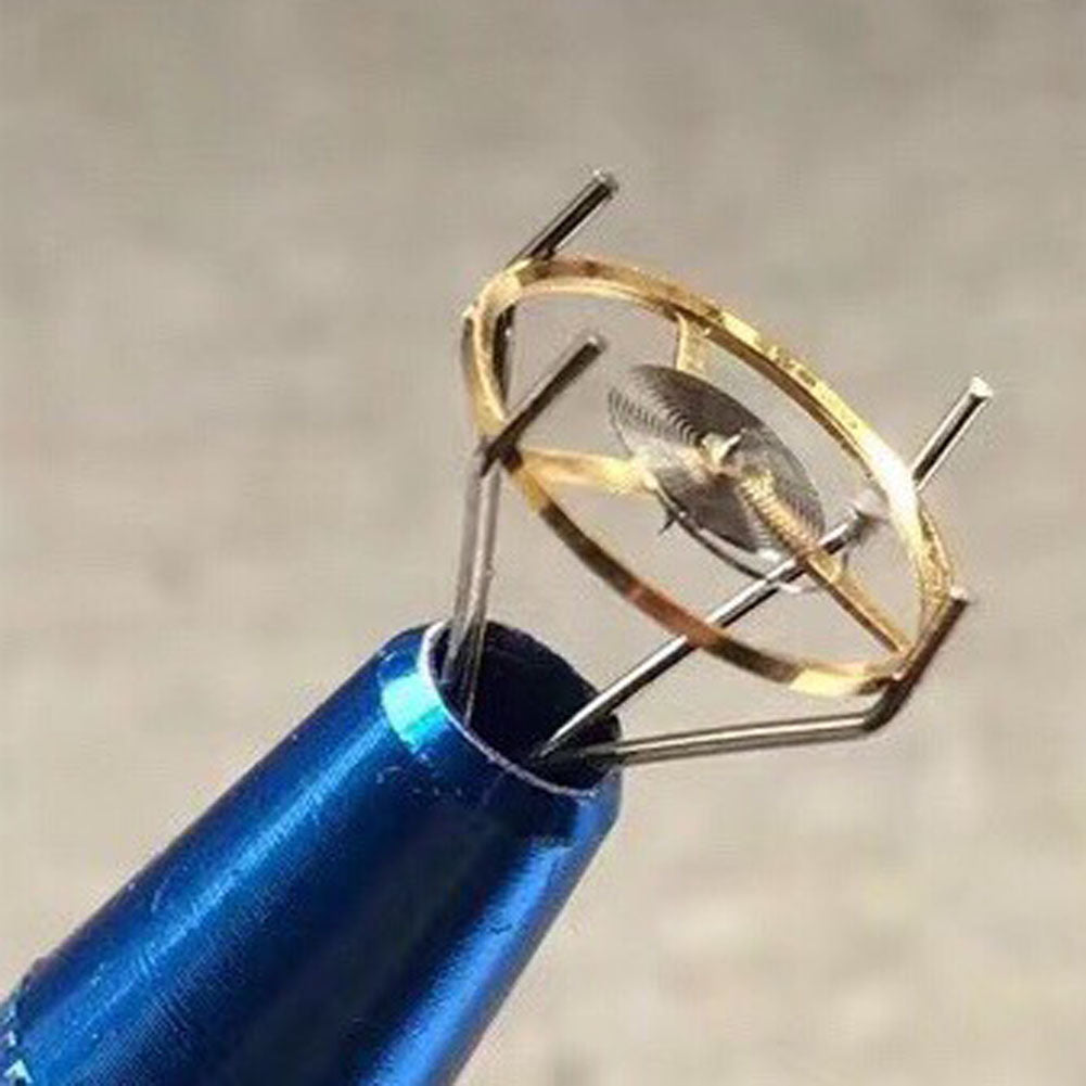 Four-prong watch repair tool for precise sub-clip balance wheel adjustments.