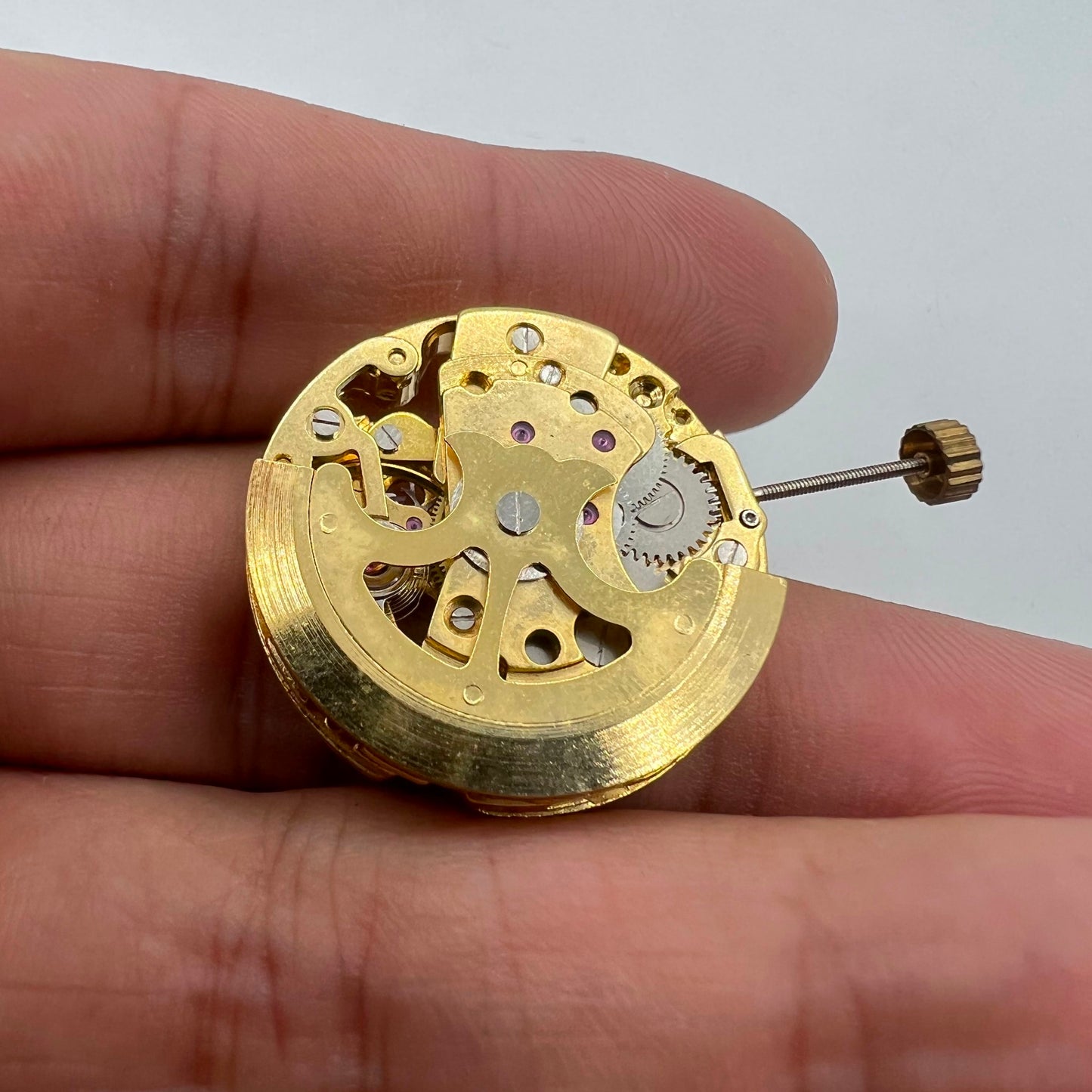 Golden 26.5mm 7120 automatic mechanical watch movement with detailed hollow craftsmanship.