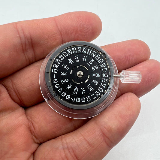 Miyota NH36A watch movement with black finish and green lume on dial, showcasing 3 crown positions for precise time setting.