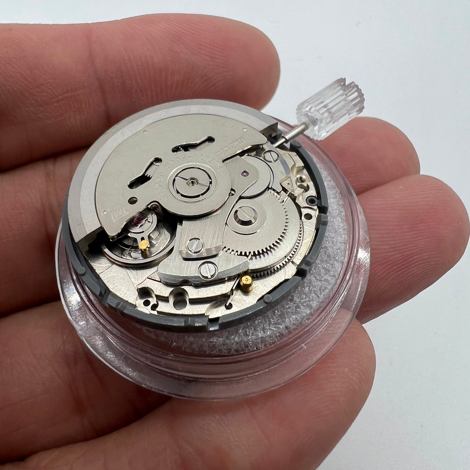 Miyota NH36A automatic watch movement in black with green lume and three crown positions for precise timing.