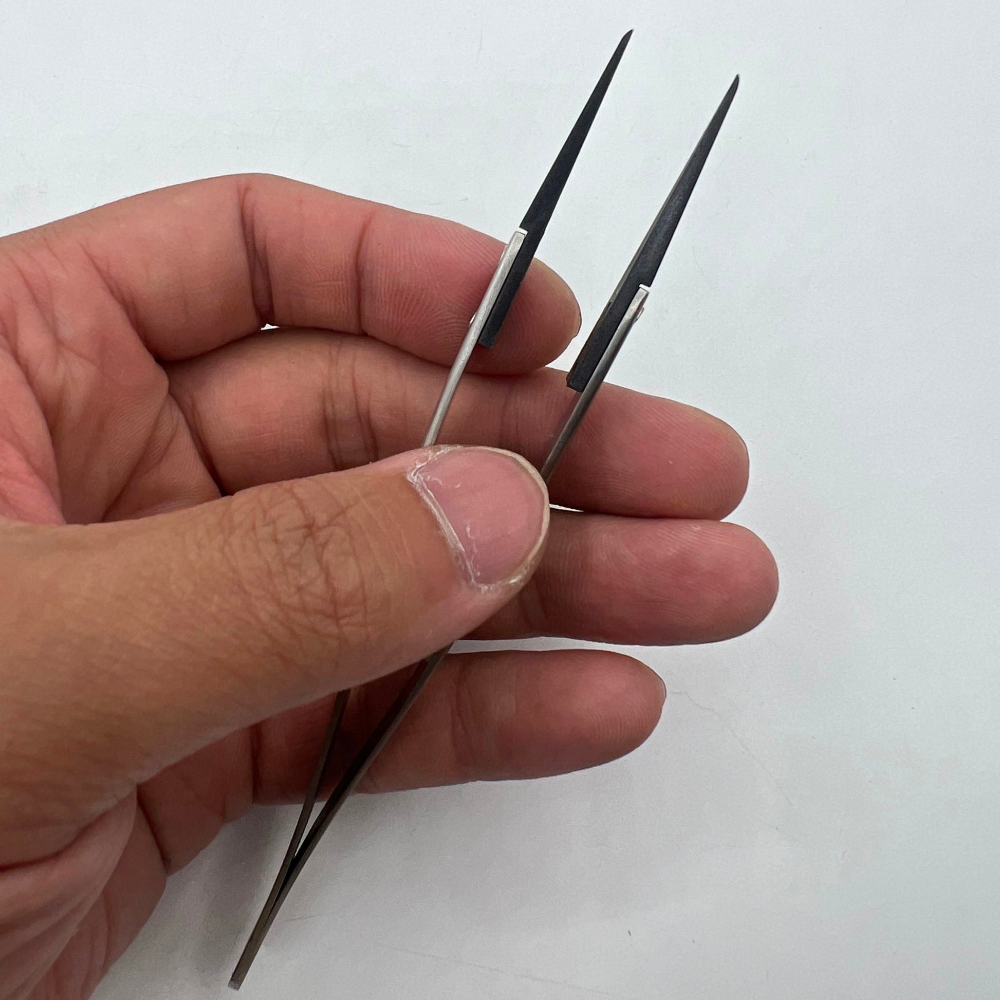 Stainless steel carbon fiber head tweezers for precise watch repair, ideal for delicate parts.