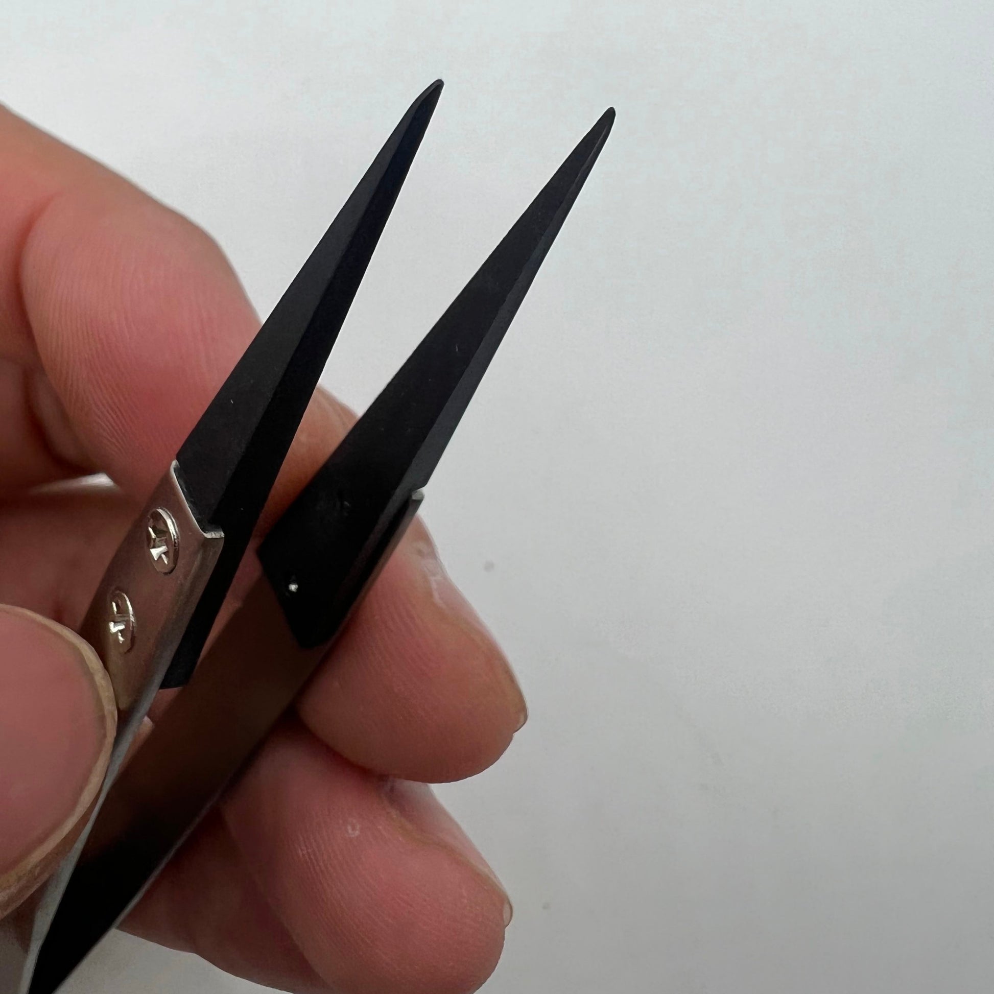 Stainless steel carbon fiber tweezers for precise watch repair and delicate accessory handling.