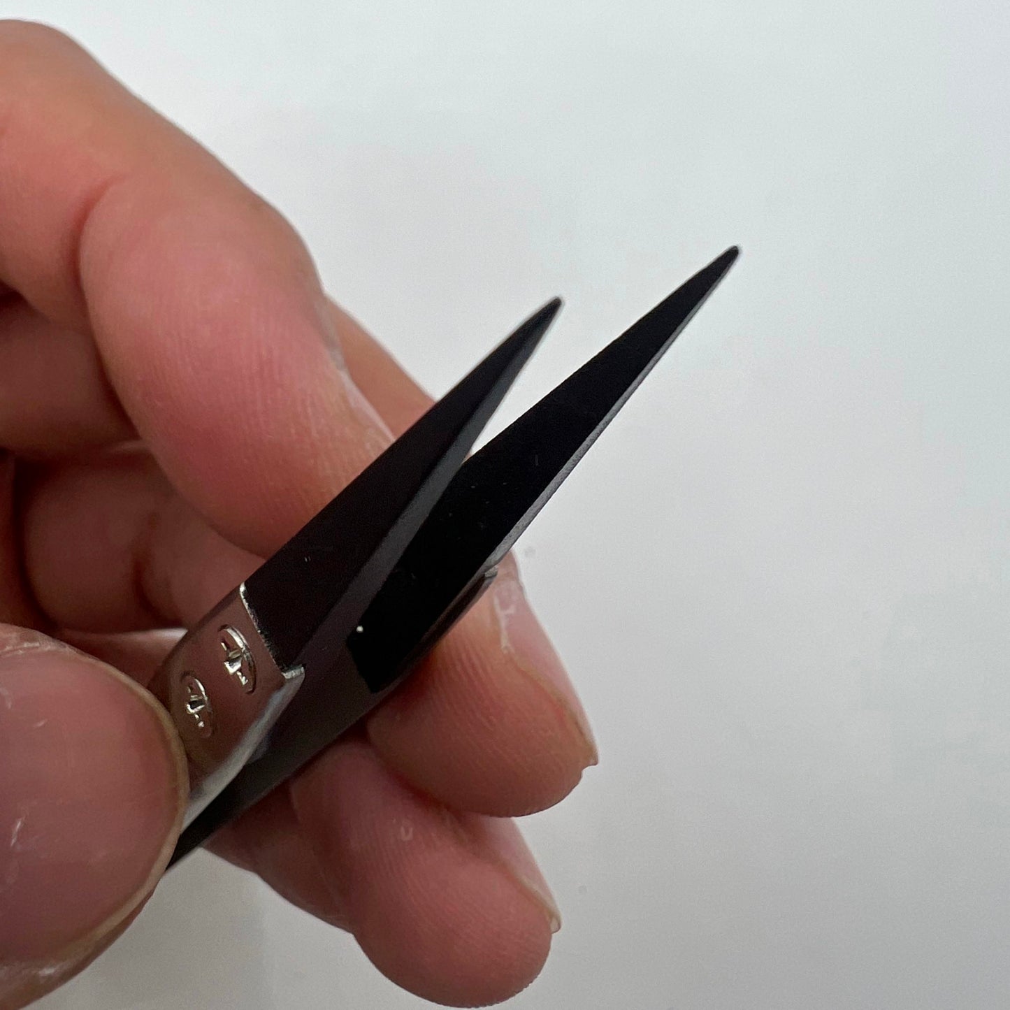 Stainless steel carbon fiber head tweezers for precise watch repair tasks.