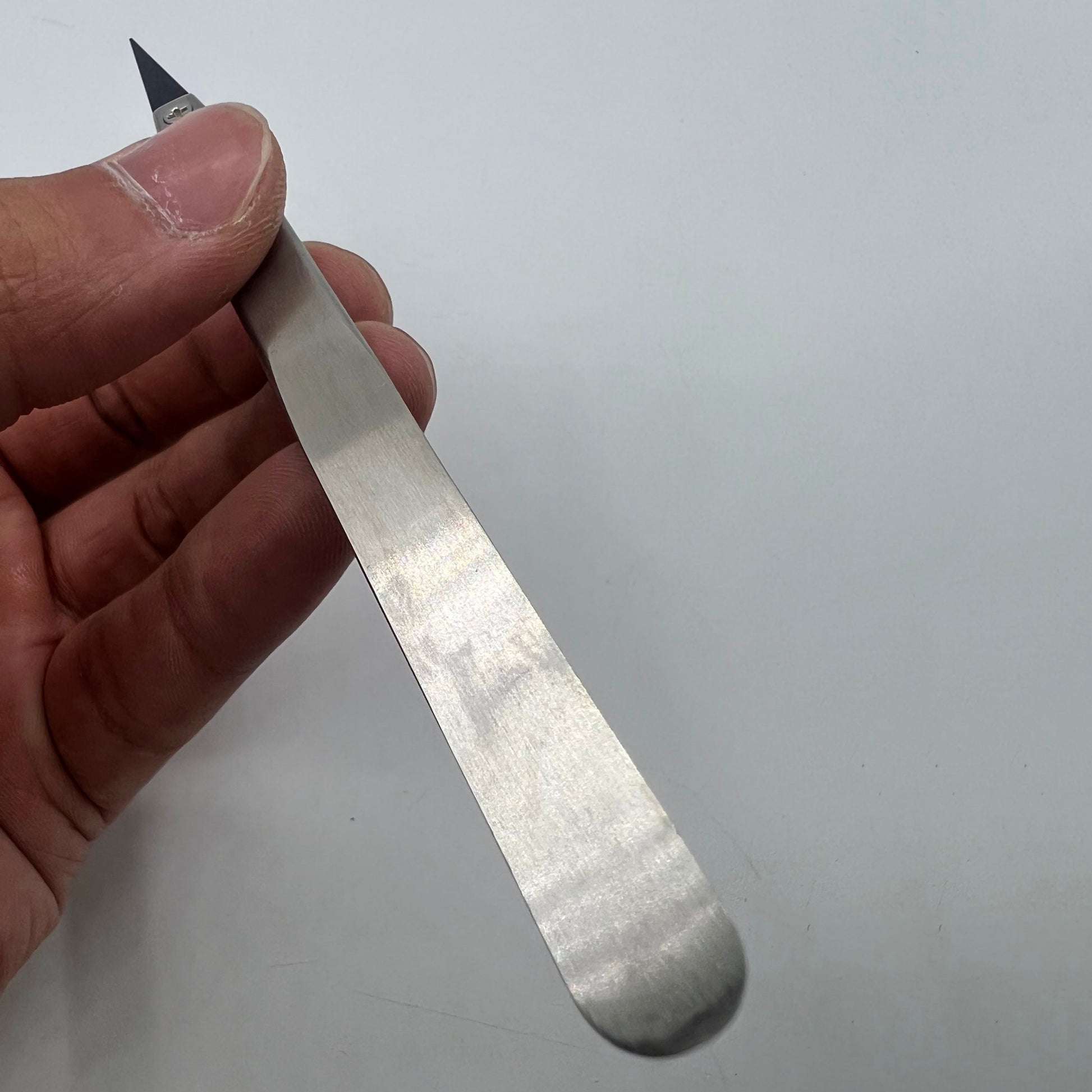 Stainless steel tweezers with carbon fiber tips for precise watch repair tasks.