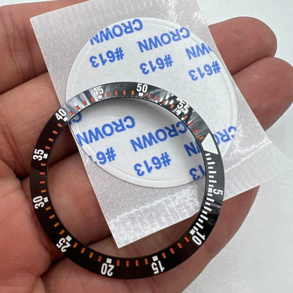 Black ceramic watch bezel insert with orange graduation, 38mm/30.5mm, durable replacement part for precise timekeeping.