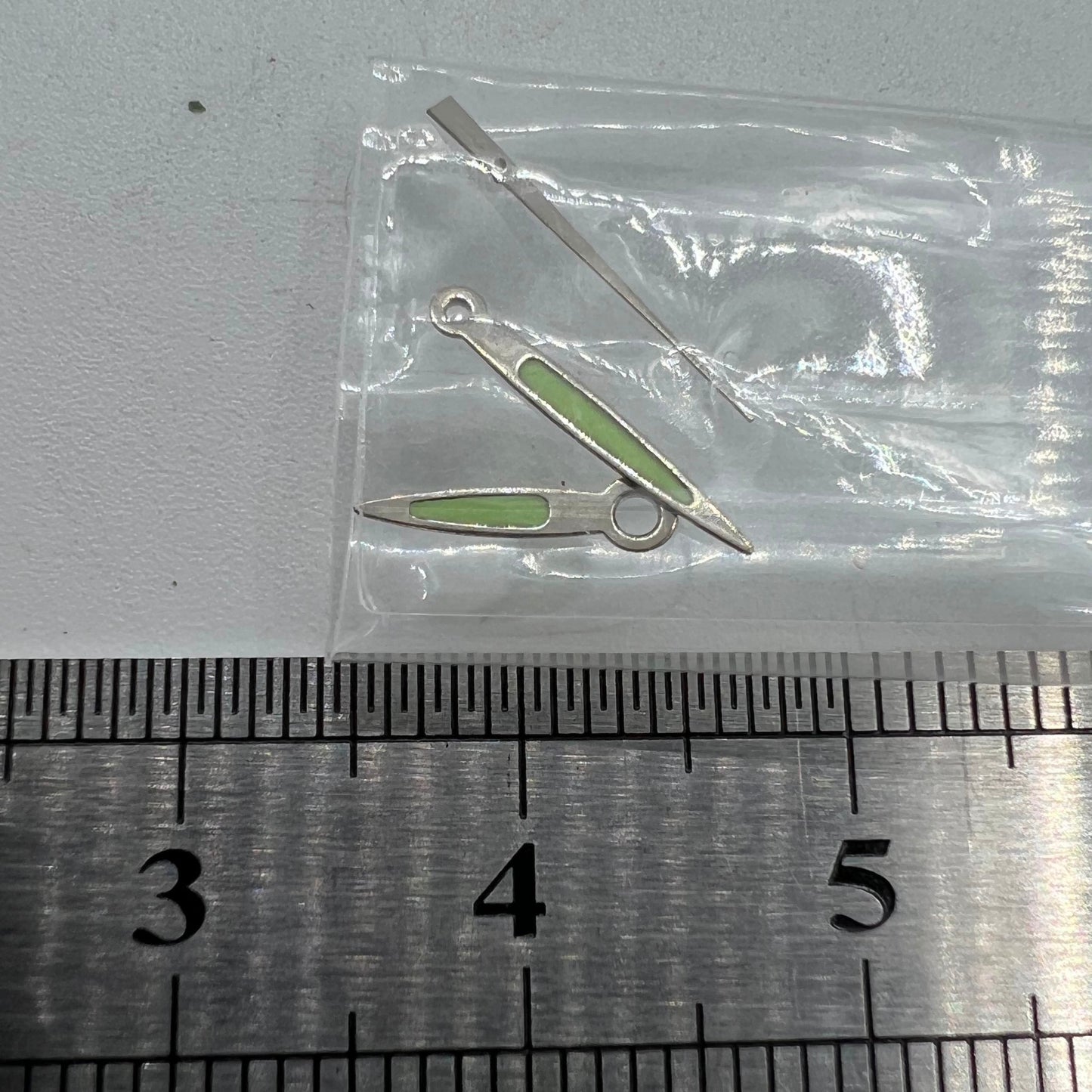 Arrow-shaped green luminous watch hands set for Miyota 2035 2115 2105 2305, glowing in low light.