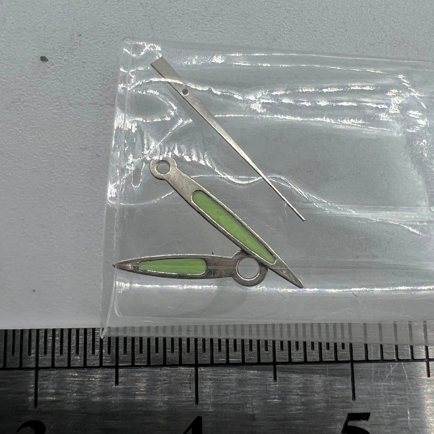 Arrow-shaped green luminous watch hands set, designed for Miyota 2035/2115/2105/2305 movements, glowing brightly in low light.