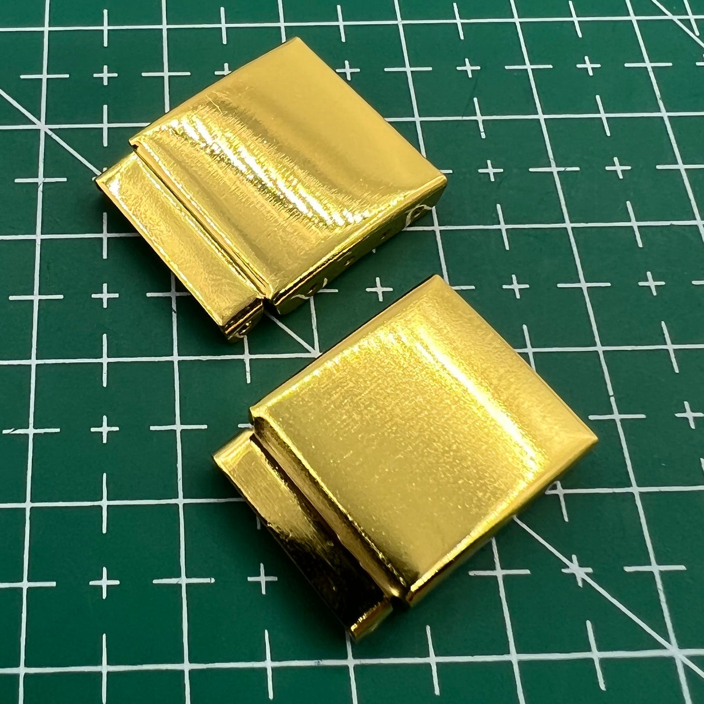 Set of 14 golden watch strap extender links for precise bracelet length adjustment, compatible with multiple brands.