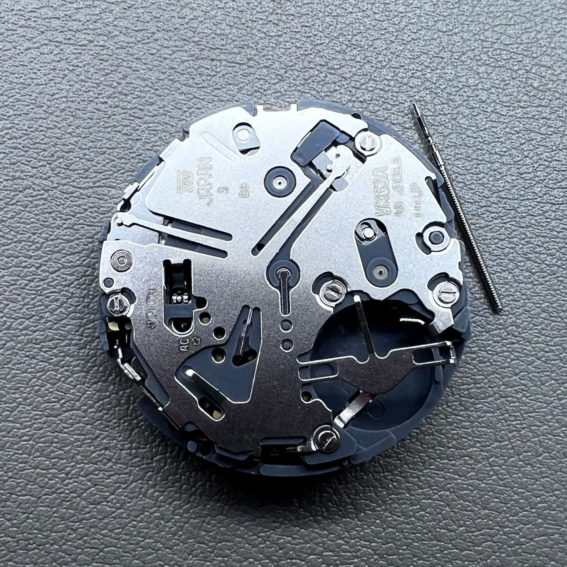 Japan Seiko VK63 quartz watch movement with black disk and white font for precise timekeeping.