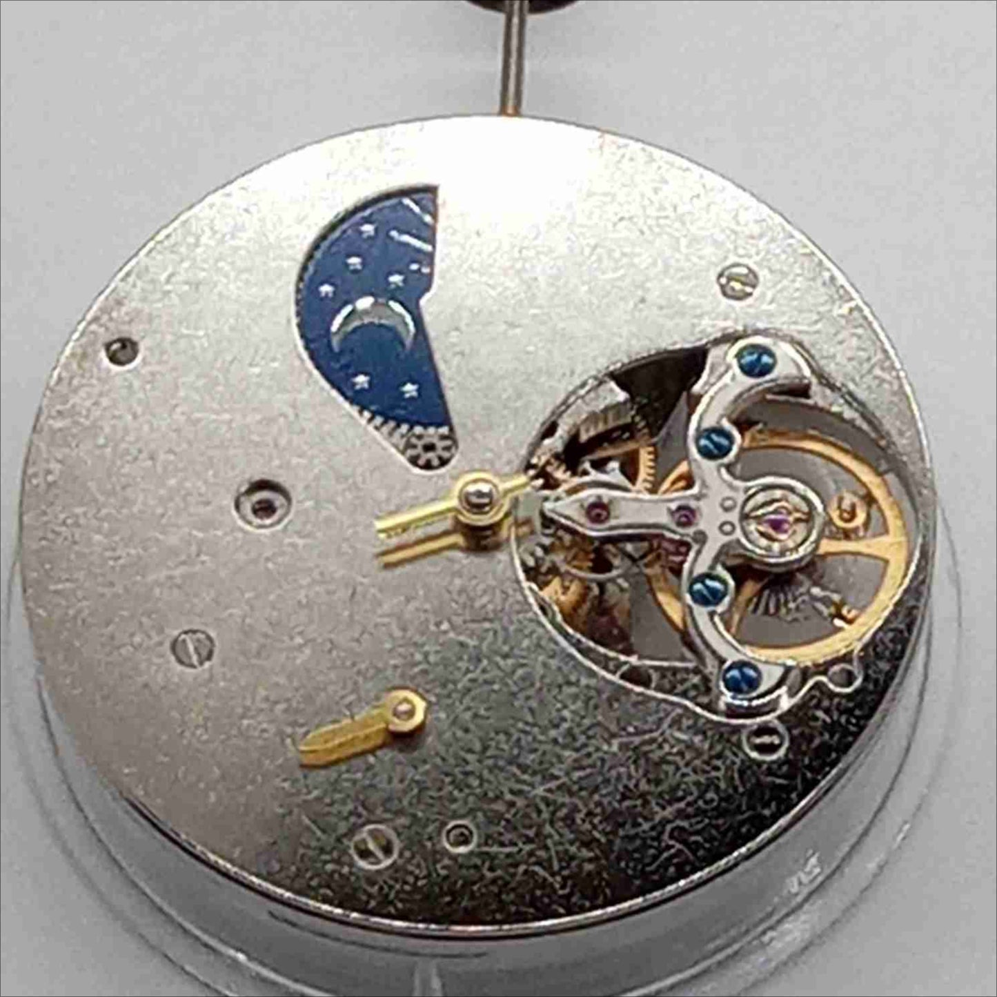 Silver mechanical flywheel watch part, precision movement component for watch repair and assembly.