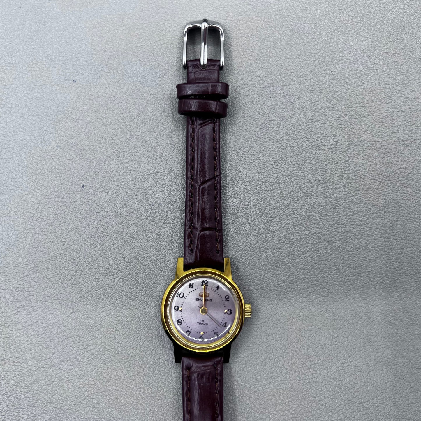 Dark Brown Strap Round Case 3 Hands Purple Background Manual Mechanical Watch
