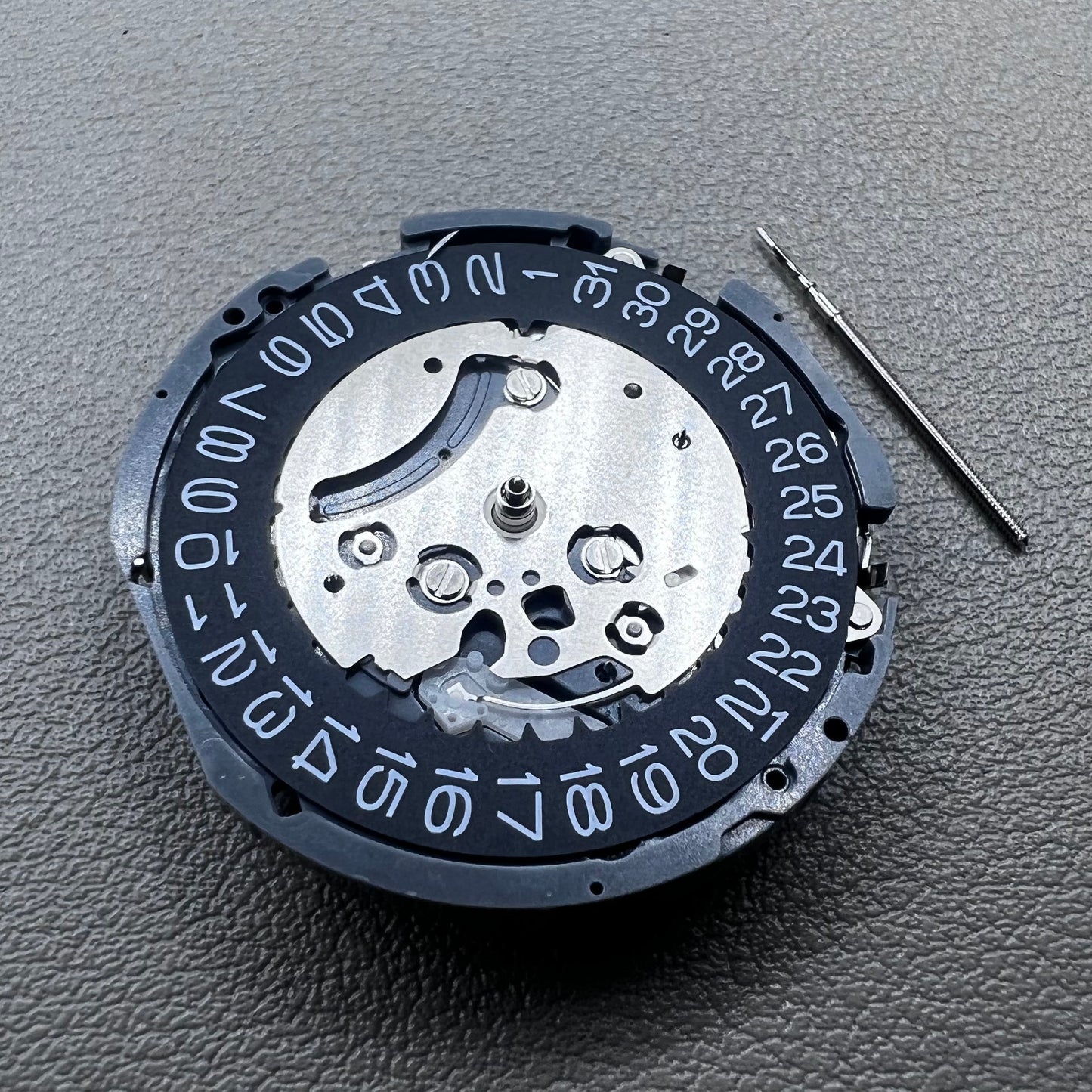 Japan Seiko VK63 quartz watch movement with black disk and white font for precise timekeeping.