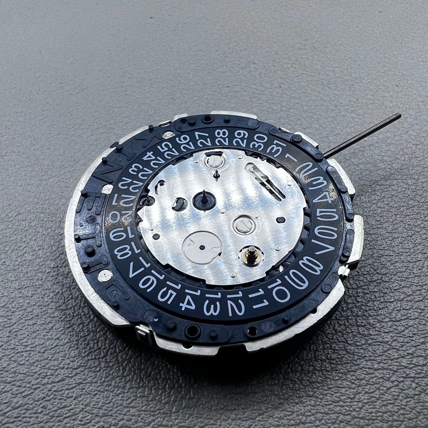 Original Japan Seiko 7L22A Quartz watch movement with black disk for precise timekeeping.