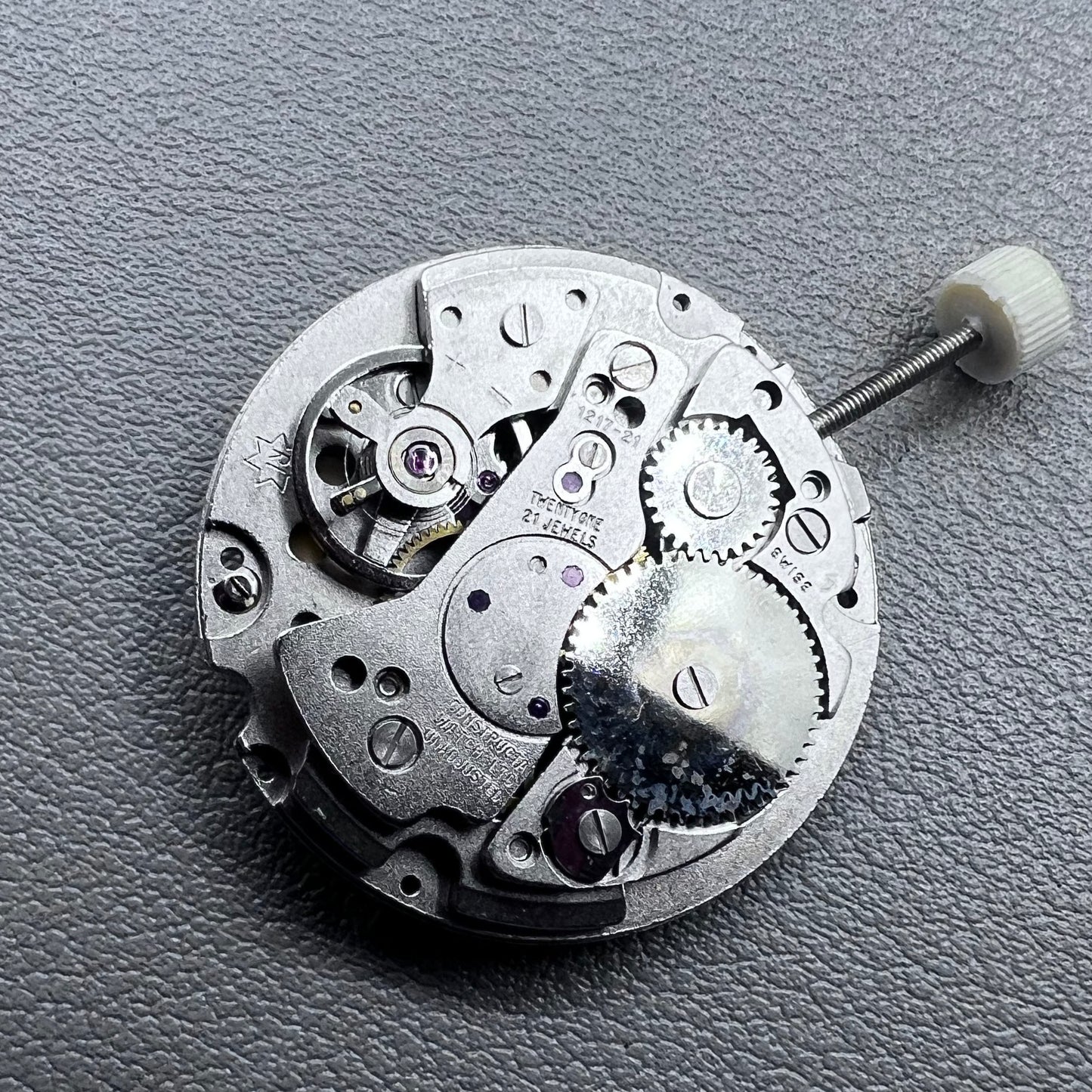 Disassembled Swiss RONDA MATIC 1217-21 manual winding watch movement showcasing intricate components.