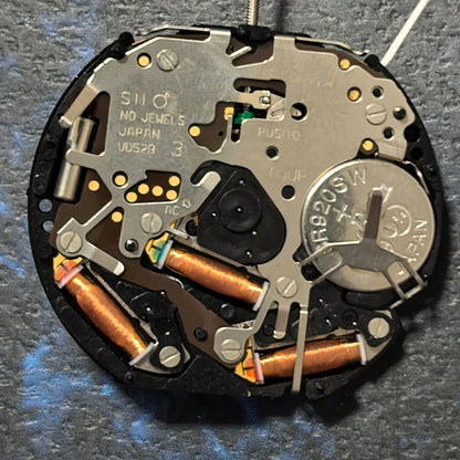 Epson VD52 quartz watch movement with 6 hands, date at 6, small seconds at 3/9/12 positions for precision timekeeping.