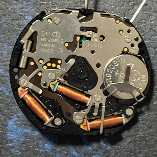 Epson VD52 quartz watch movement with 6 hands, date at 6, and small seconds at 3/9/12 positions.